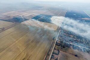 Top view of the small village. Smoke from the burning of straw i photo