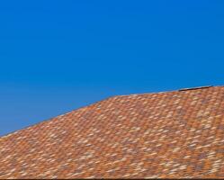 Roof from multi-colored bituminous shingles. Patterned bitumen shingles. photo