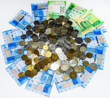 Russian banknotes and coins. A handful of coins on new Russian banknotes in denominations of 2000 and 200 rubles. photo