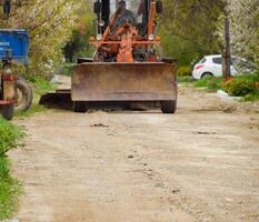 calificador en un suciedad grava la carretera. calle reparar por agregando escombros. foto