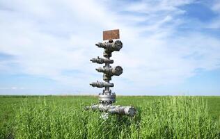 Canned oil well against the sky and field photo