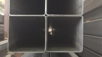 Stacked steel pipe with sunlight reflecting on the interior walls of central part. Rectangular metal pipe for construction. Pipes rectangular section. video