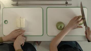 Kinder Schneiden Apfel und Käse Aussicht von das oben. Kinder wenig Mädchen und Junge Kochen beim Küche video