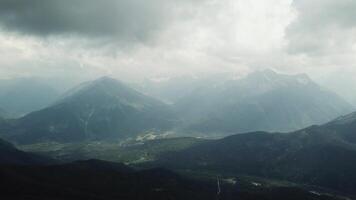 Aerial View. Flying over the high mountains in beautiful clouds. Flight in the clouds. Beautiful landscape video