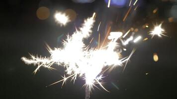 Beautiful sparkler on shiny background, close up. Christmas and new year party sparkler on bokeh background. Close-up view of lit up holiday sparkler video