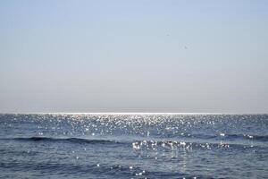 Sea line of the horizon. Sea and sky. The waves and glare of the sun are reflected from the waves of the sea. Seascape. photo