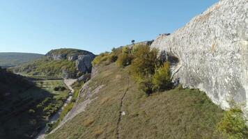 Visualizza di il montagna valle. sparo. enorme grigio pietre su un' superiore di verde colline video