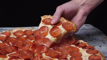 Taking slice of pizza, melted cheese dripping. Frame. Close-up Of People Hands Taking Slices Pizza black background video