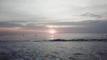 solnedgång på de strand - lugn idyllisk scen av en gyllene solnedgång över de hav, vågor långsamt stänk på de sand. video. vågor kraschar försiktigt på tyst sandig strand video