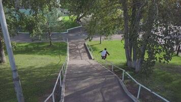 agresivo en línea rodillo blader moler en carril en Parque de patinaje afuera. acortar. verano extremo deporte hacer ejercicio al aire libre en patinar parque. varios trucos video