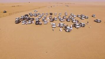 4x4 SUVs cars driving through the sand dunes in the desert of Abu Dhabi. Stock. Top view on SUVs in the desert video