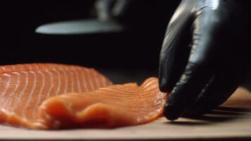 Nahansicht von Sushi Koch im Handschuhe Scheiben frisch Lachs beim Sushi Bar. Schneiden Lachs Filets video