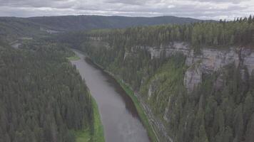 Flying over the beautiful mountain River and beautiful forest. Clip. Aerial view of mystical river at sunrise with fog, sun above the river aerial video