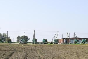 Open-air garage for agricultural machinery. Old tractors, combines and towed equipment photo