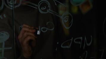 Close-up of a Man Writing Formulas on a Glass Whiteboard. Stock. Close-up of a scientist writing on the glass formula video