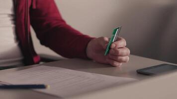 Online payments concept. Stock. Business man holds a credit card in his hand while using or typing identification numbers after buying goods from retailer stores via the internet video