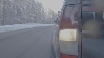 faro de cerca en Nevado carreteras. el coche paseos en un cubierto de nieve la carretera video