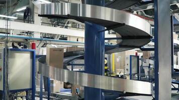 Cardboard boxes on conveyor belt in factory. Clip. Production line on which the boxes move in a spiral video