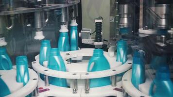 Liquid detergent on automated production line. Clip. Automated production line of washing fluid. Machinery for bottling video