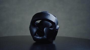 Black boxer helmet on the table. Protective helmet on the head during training protects the head from bumps video