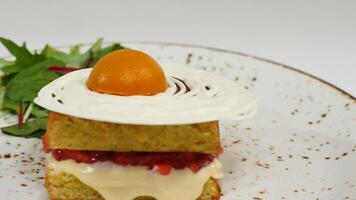 Vittoria spugna torta con fragole, marmellata e frustato crema con un' tagliare su pezzo su un' bianca sfondo video