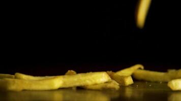 Fries falling on black background. Ready delicious French fries falling on a black background, the concept of fast food video