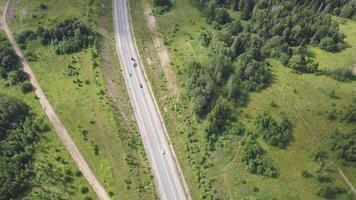 Aerial view of highway with trees and mountain. Clip. Top view of the asphalt road in forest area video