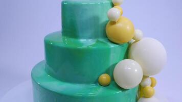 Stylish mousse cake with turquoise mirror glaze. Cake with turquoise mirror glaze decorated with chocolate balls video