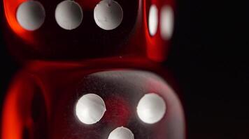 Red dices on black background. Red dice standing on each other, macro on black background video