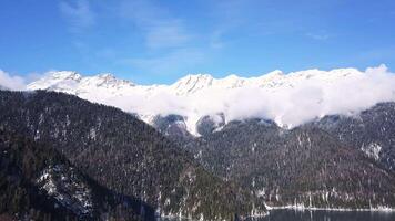 panoramico Visualizza di bellissimo bianca inverno Paese delle meraviglie scenario con nevoso montagna vertici. clip. freddo soleggiato giorno con blu cielo e nuvole video