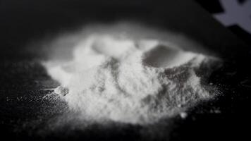 DRUGS. Man does a lines of heroin by plastic card - Close up. Plastic card and white powder. Lines and pile of cocaine on wooden table. Macro video
