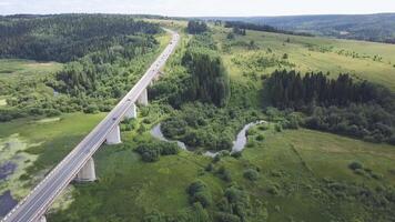 Aerial view of highway with trees and mountain. Clip. Top view of the asphalt road in forest area video