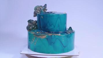 Mousse cake decorated in marine style covered with blue mirror glaze and white chocolate seashells. European french dessert. video