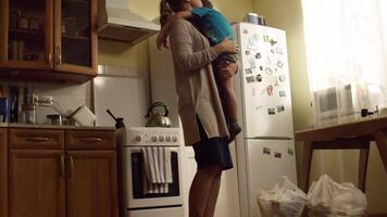mamá abrazos hijo en el cocina. concepto de cuidado y amor. excelente relación con madre y hijo video