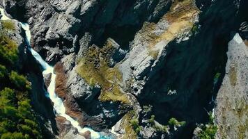 escénico ver terminado río con blanco agua y distante montaña con alto cascada. ver desde el parte superior de el cascada y el Nevado montañas video