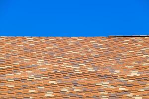 Roof from multi-colored bituminous shingles. Patterned bitumen shingles. photo