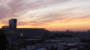 Buildings and football fields and morning sunrise. Dawn in the city in the background of football stadium video