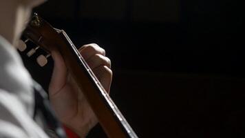 Close up of guitarist hand playing acoustic guitar. Close up shot of a man with his fingers on the frets of a guitar playing video