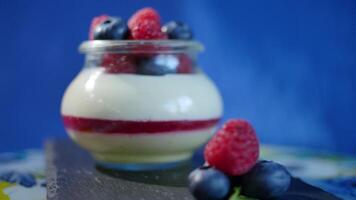 Homemade yogurt with blueberries in a glass jar. Strawberry in Yogurt, close up. video