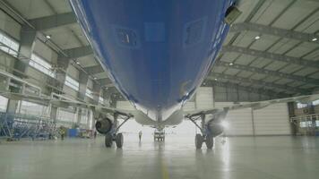 avião dentro hangar, traseiro Visão do aeronave e luz a partir de janelas. ampla passageiro aeronave dentro uma hangar em serviço manutenção video