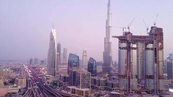 antenn se av stadens centrum dubai i en sommar dag, förenad arab emiraten. antenn se av stadens centrum dubai med byggnader skyskrapor och en dammig horisont på soluppgång. burj khalifa video