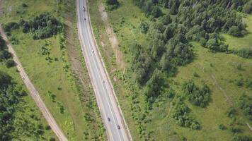 Aerial view of highway with trees and mountain. Clip. Top view of the asphalt road in forest area video