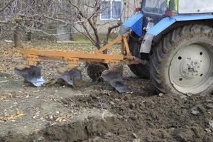 Tractor plowing the garden. Plowing the soil in the garden photo