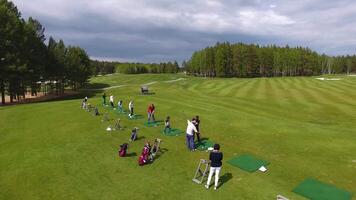 Golfers hitting golf shot with club on course while on summer vacation, aerial video