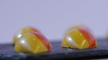 close up of two caramel candies on white background. Salted caramel pieces. Row of caramel candies on white background video