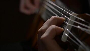 cerca arriba de guitarrista mano jugando acústico guitarra. cerca arriba Disparo de un hombre con su dedos en el trastes de un guitarra jugando video