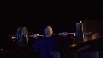 tyngdlyftare hissar de bar ovan hans huvud. styrka Träning med en enorm vikt. stark crossfit idrottare i de mitten en tung ryck hiss i en crossfit låda Gym video