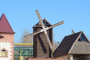 Decorative wooden mill. Mill to decorate the streets. Houses and buildings photo