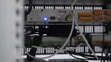 retour de le serveur installée dans le serveur chambre. beaucoup câbles sont connecté à une puissant des ordinateurs. de face panneau de le central routeur. optique liens de une puissant l'Internet serveur. lien de video