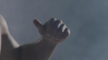 Clenched fist on dark background with smoke. Close-up of hand of boxer ready for a fight. Strong arms and clenched fists video